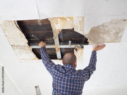 Man repairing collapsed ceiling.