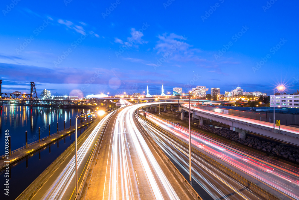 traffic on road with cityscape and skyline of portland at twilig