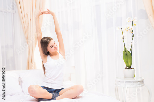 Woman Stretching in Her Bed. A Girl waking up in The Morning