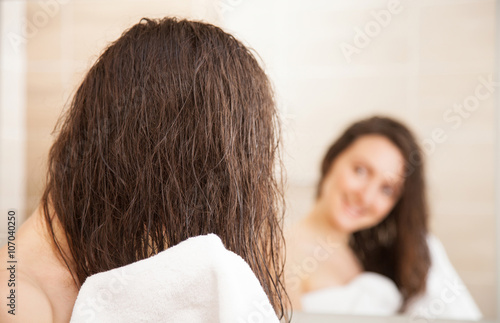 Young woman wiping hair after a shower