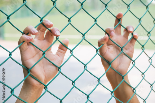 Hands with Mesh cage, Hands with steel mesh fence , freedom / Independence / hope concept.