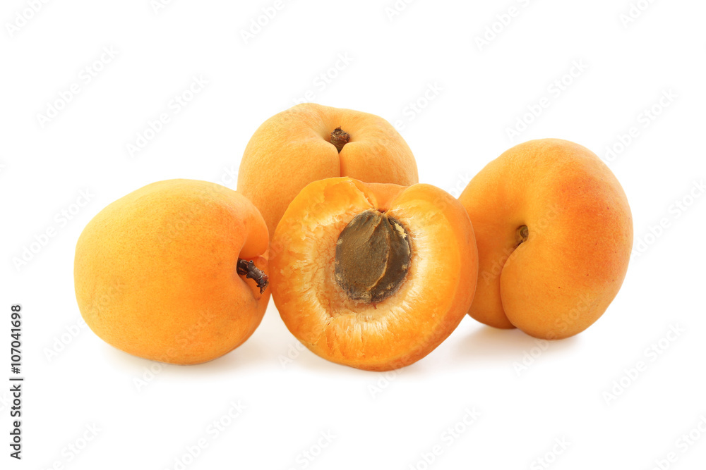 Three apricots and helf isolated on white Three apricots and helf isolated on white