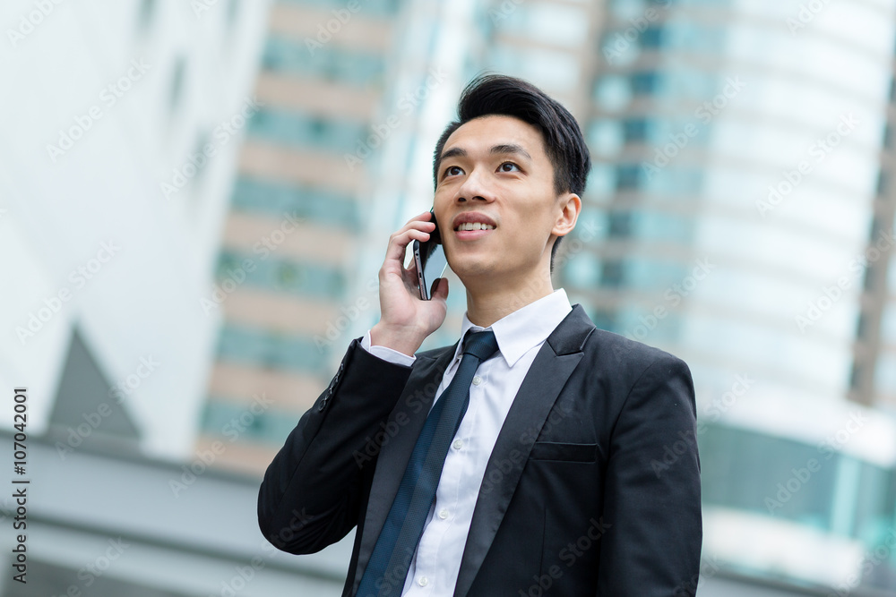 Businessman talk to mobile phone outside office in Hong Kong Businessman talk to mobile phone outside office in Hong Kong