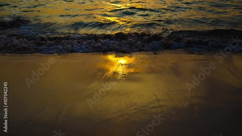 waves and sand on a tropical beach at sunset