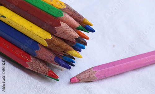 Team brainstorming, high angle view color pencils Colour Pencils with different one on white background, Business concept