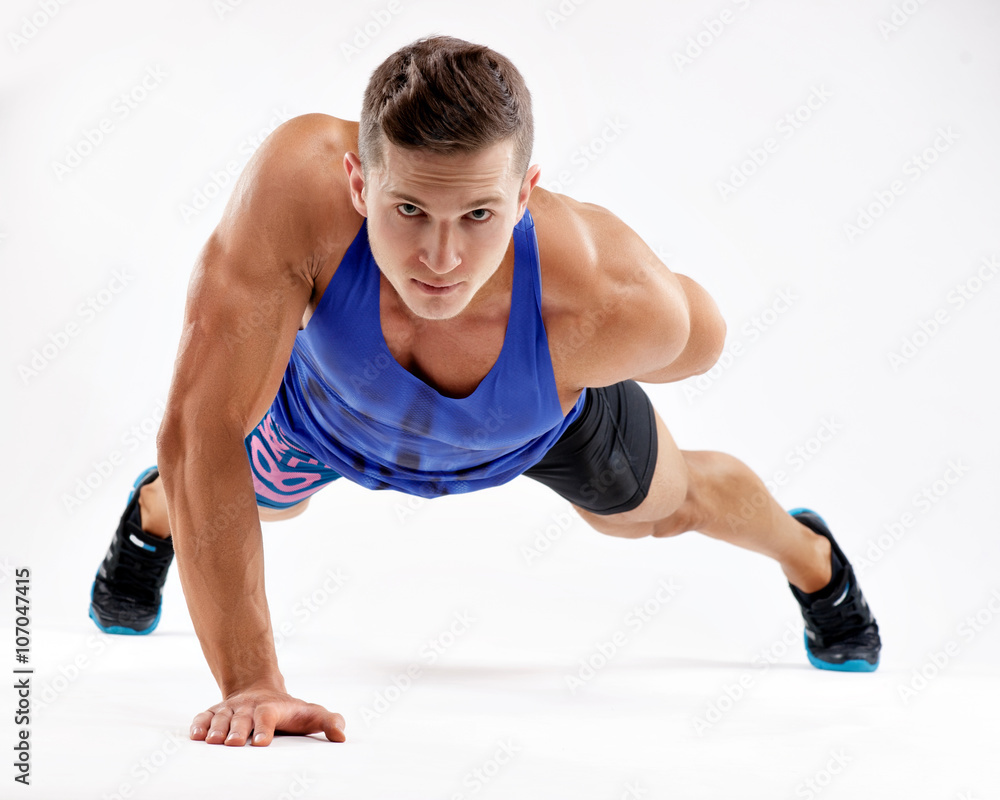 Strong young athlete doing push-ups on one hand. Sports concept Strong young athlete doing push-ups on one hand. Sports concept