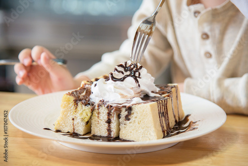 Asian boy eating honey toast photo