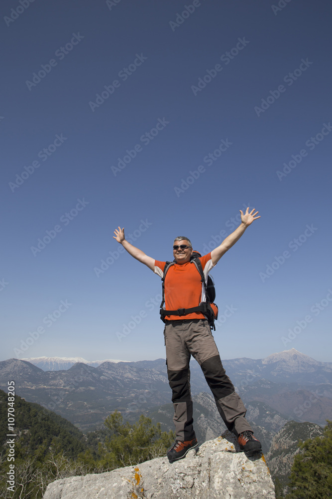 A traveler stands on top of a mountain and looks out to sea. A traveler stands on top of a mountain and looks out to sea.