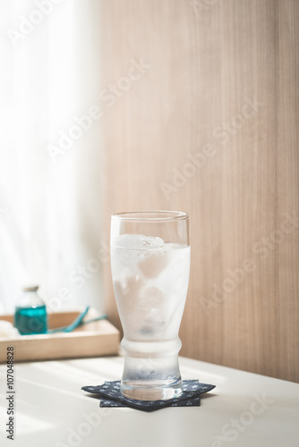 Glasses with ice cubes on wooden table