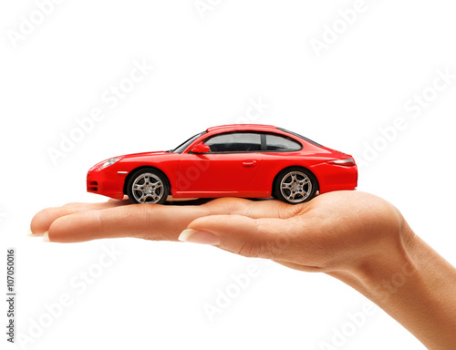 Woman's hand holding a red toy car isolated on white background. Business concept