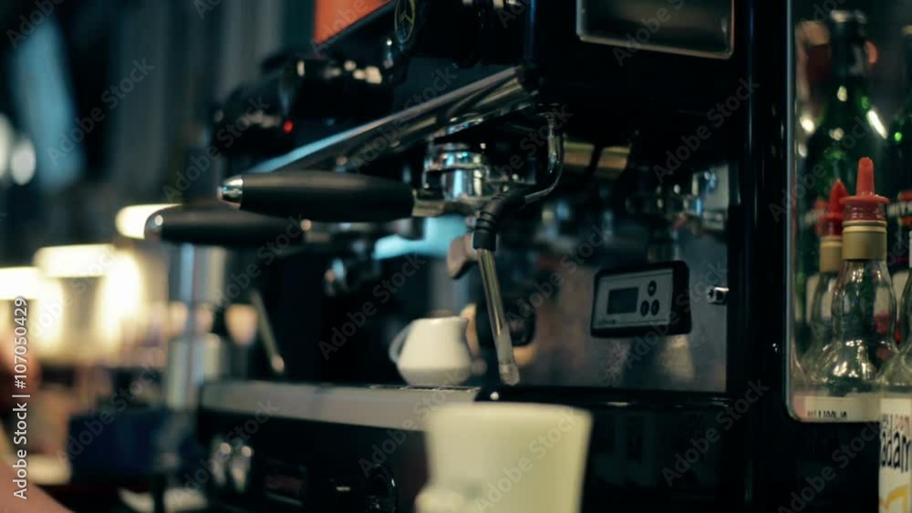 Bartender makes a latte at the coffee machine Bartender makes a latte at the coffee machine
