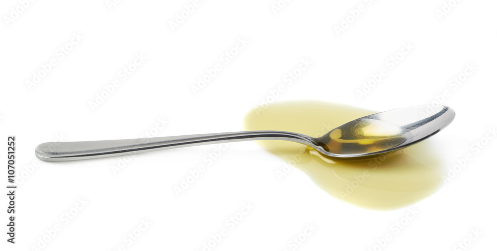 Steel spoon in a puddle of olive oil Steel spoon in a puddle of olive oil