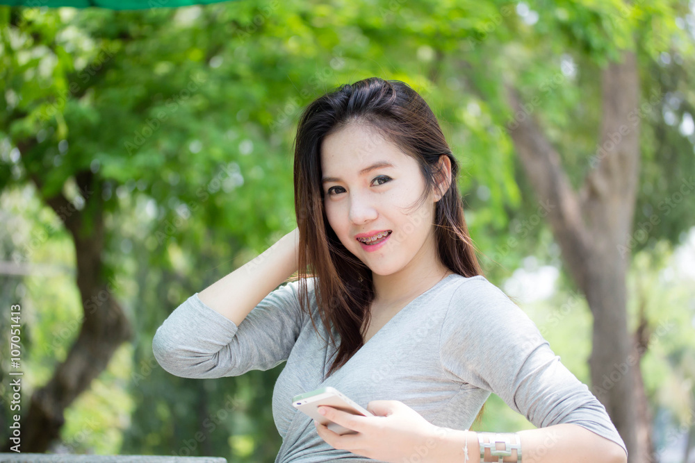 Portrait of thai adult beautiful girl using her smart phone. Portrait of thai adult beautiful girl using her smart phone.