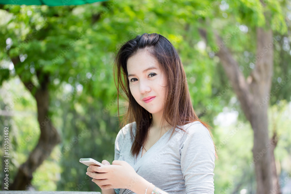 Portrait of thai adult beautiful girl using her smart phone. Portrait of thai adult beautiful girl using her smart phone.