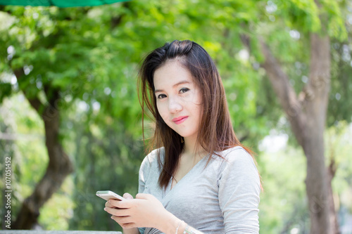Portrait of thai adult beautiful girl using her smart phone.