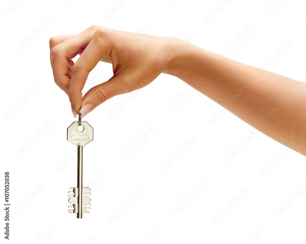 Woman's hand holding silver key isolated on white background. Close up Woman's hand holding silver key isolated on white background. Close up