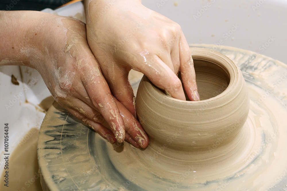 pottery. the teacher teaches the student work on the potter's wheel.