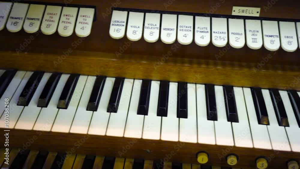 Pan along a vintage organ keyboard with two levels of keys visible ...
