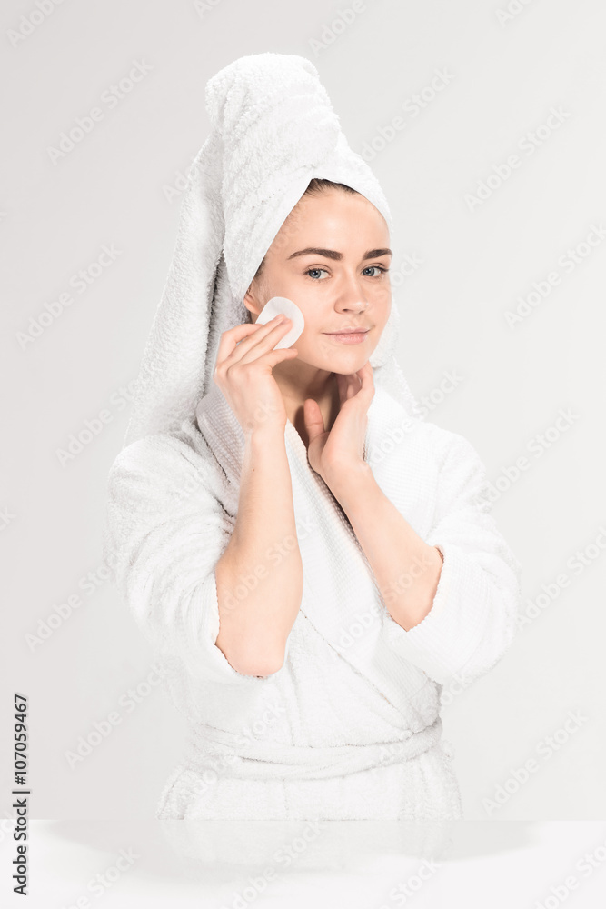 Woman cleaning face in bathroom Woman cleaning face in bathroom