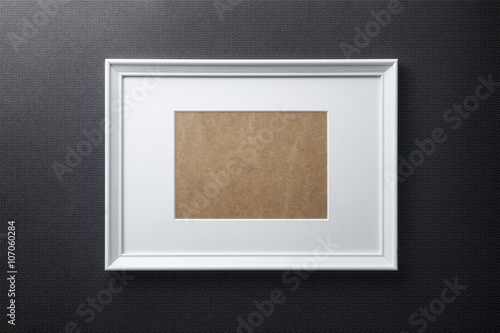 White plain empty wood picture frame with white mat passe-partout on black bricks background