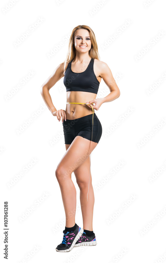 Sporty woman in sportswear measuring her body isolated on white Sporty woman in sportswear measuring her body isolated on white
