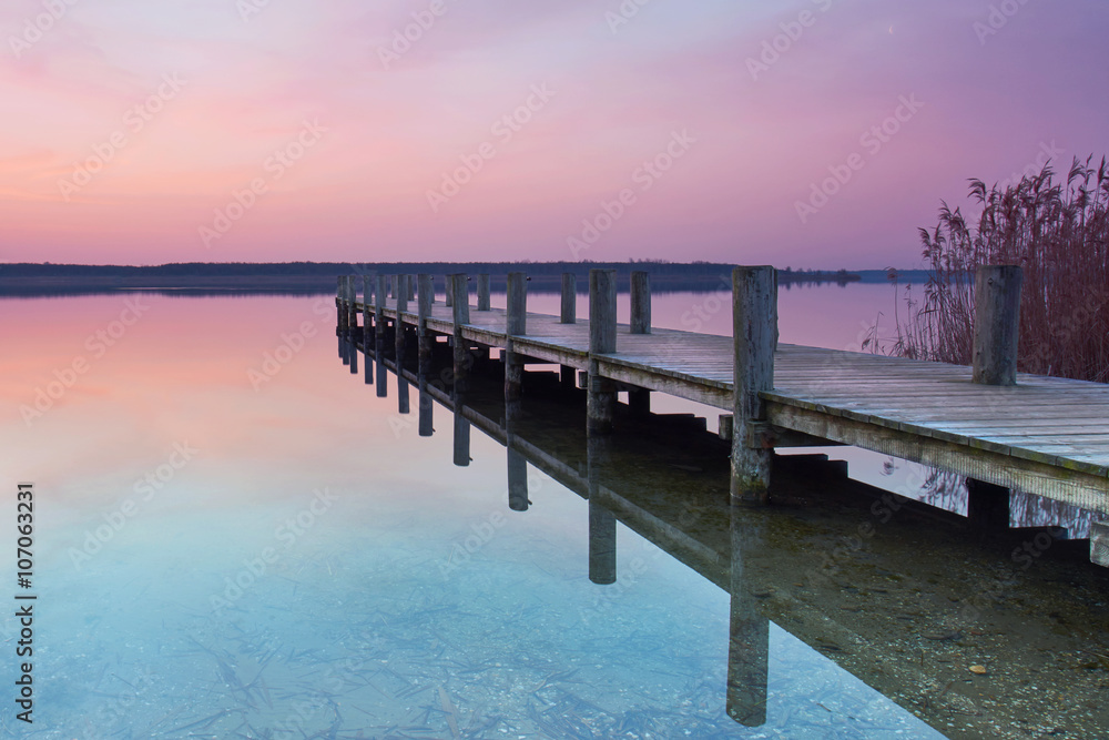 langer Holzsteg am See zum Sonnenaufgang