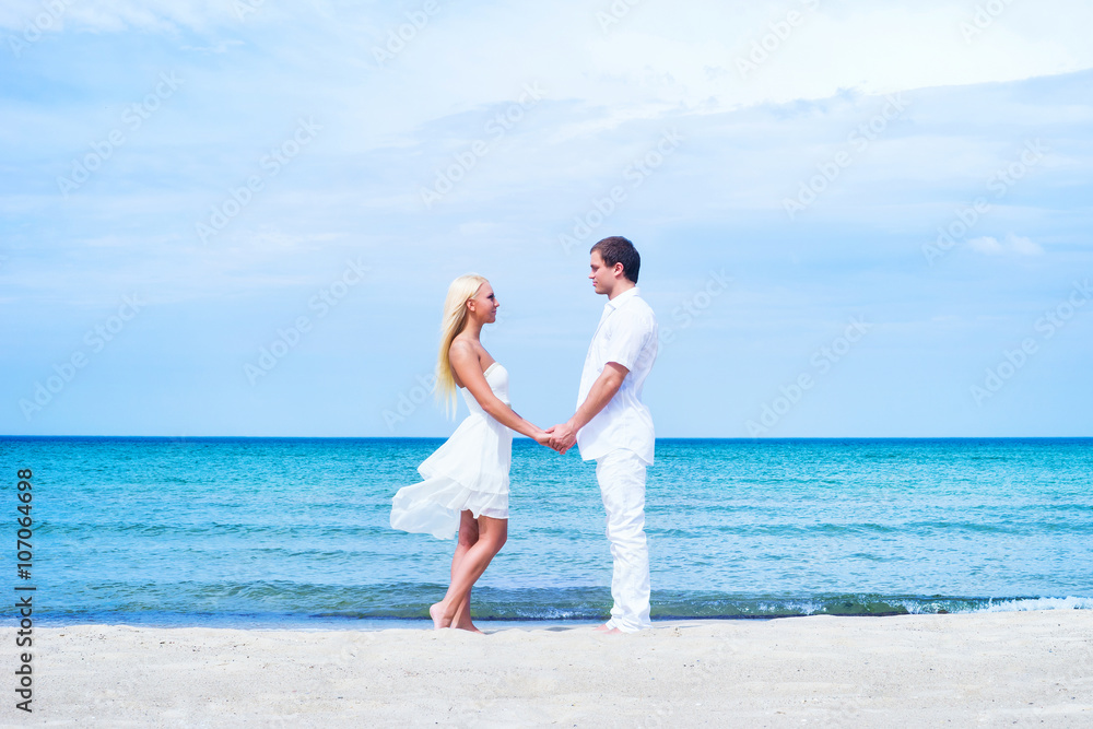 Loving couple walking and embracing on a summer beach Loving couple walking and embracing on a summer beach