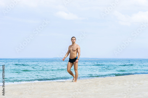 Young  fit handsome man on a summer beach