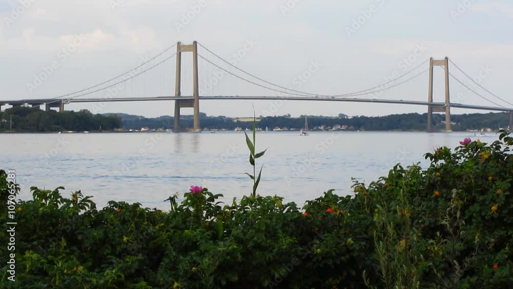 Large bridge in Denmark. Several cars, bus, trucks and other vehicles crossing the bridge during daytime. Large bridge in Denmark. Several cars, bus, trucks and other vehicles crossing the bridge during daytime.