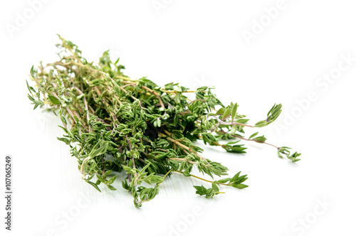 Green thyme herb branches on white wooden table background