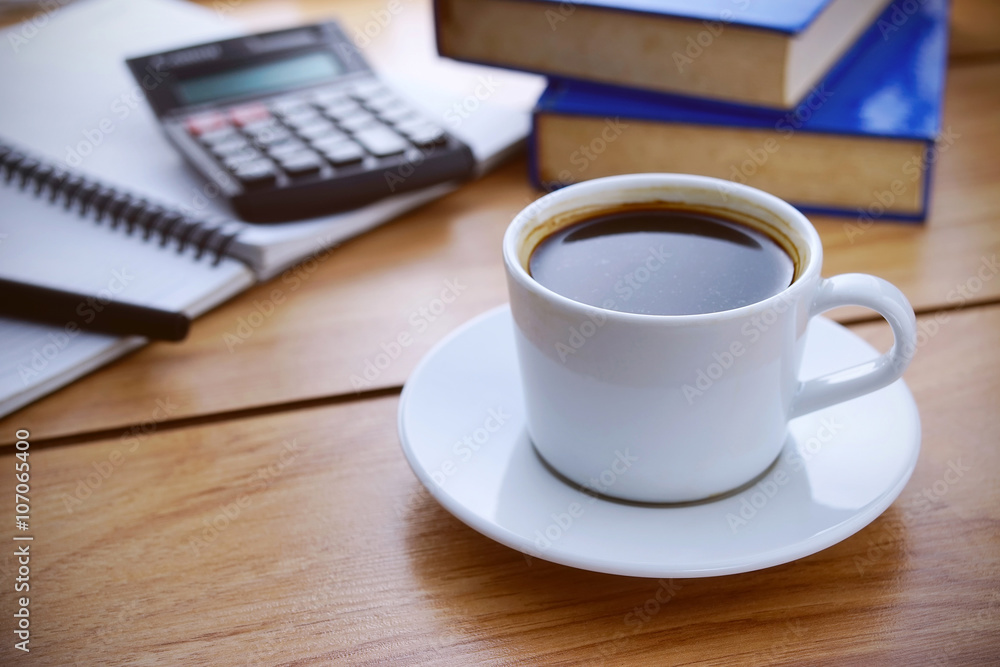 Coffee break. Notepad, books and calculator on wooden table. War Coffee break. Notepad, books and calculator on wooden table. War
