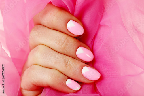 Female hand with manicure on a pink background