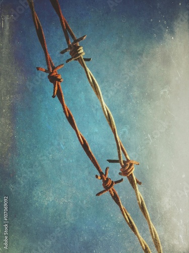 Barbed wire against blue sky