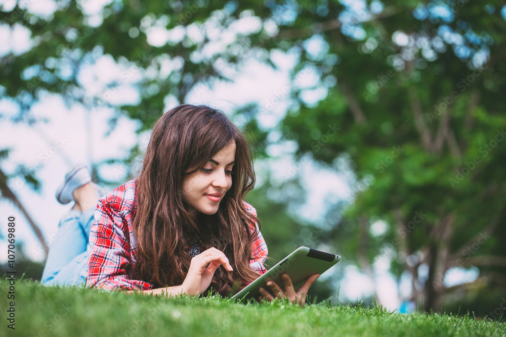 Portrait of young beautiful smiling woman with tablet pc, outdoors.