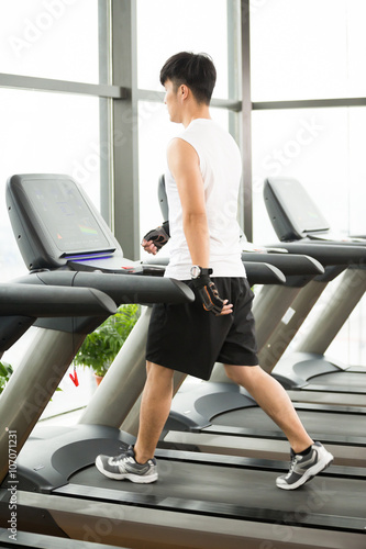young handsome asian man works out in modern gym