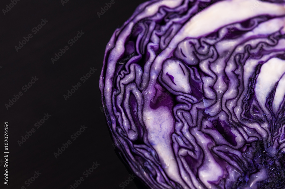Obraz premium Purple cabbage cut in half dark background, close up space for text