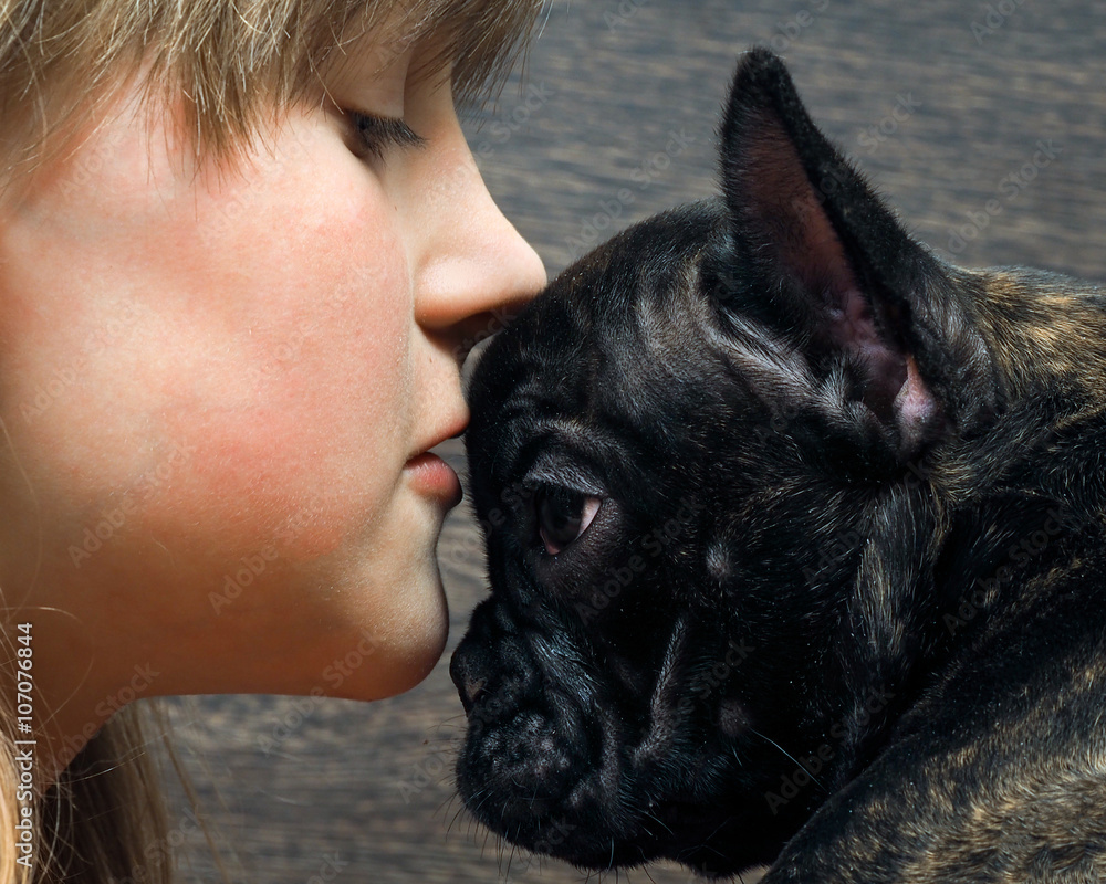 Kiss Dog and child. The girl's face and large dog muzzle. Concept - the  relationship of man and dog. Dog black French bulldog. Girl teenager with  blond hair Stock Photo | Adobe Stock