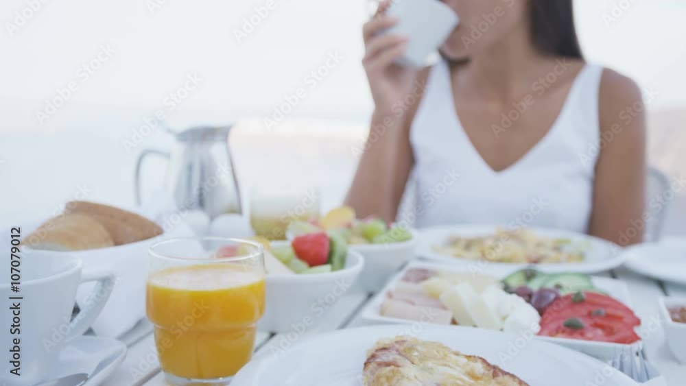 Breakfast. Variety of healthy and delicious food are served on table. Woman is drinking coffee during breakfast. Meal is at terrace. Breakfast. Variety of healthy and delicious food are served on table. Woman is drinking coffee during breakfast. Meal is at terrace.