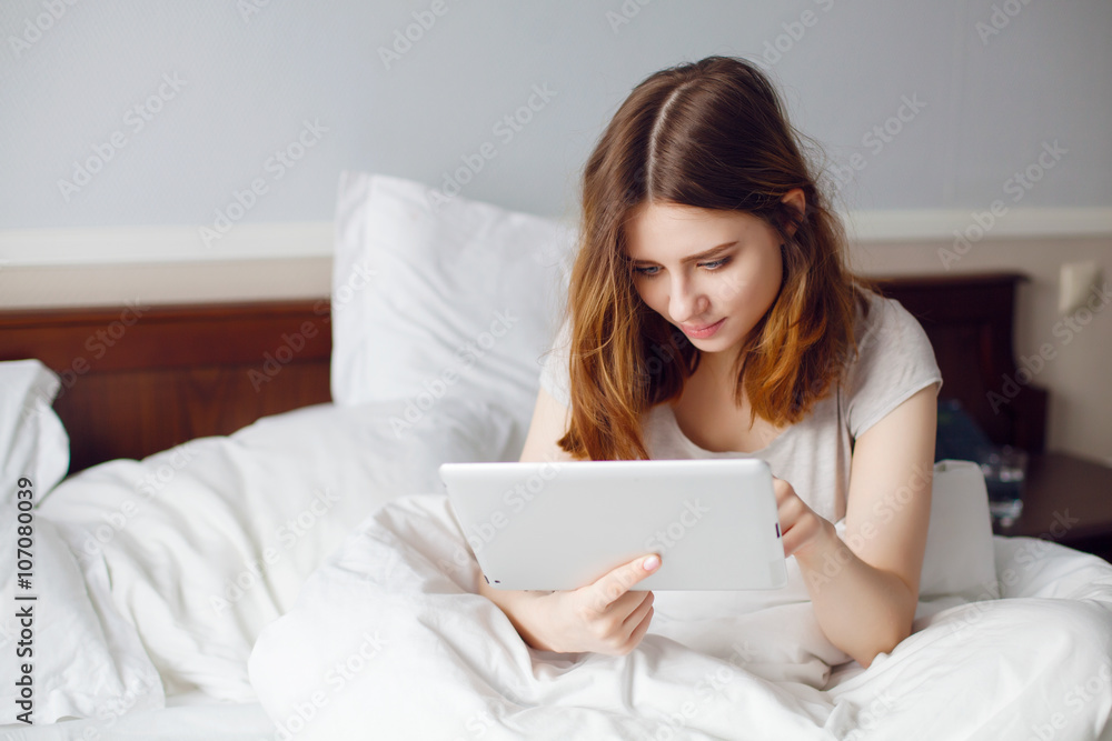 Happy girl watching videos tablet lying on bed at home Happy girl watching videos tablet lying on bed at home