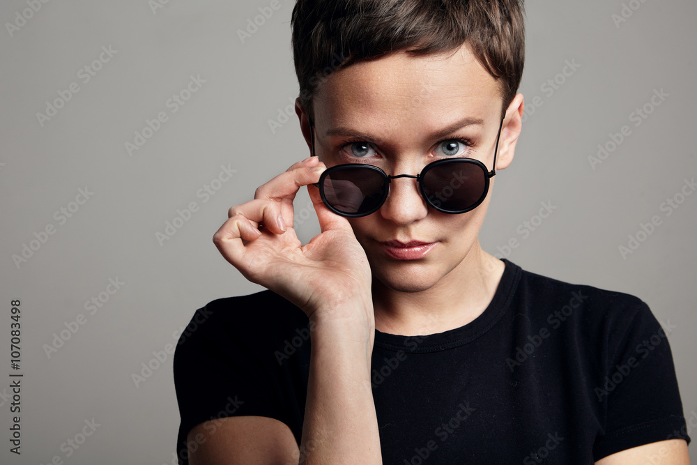 woman watching over the glasses. Blue eyes woman watching over the glasses. Blue eyes
