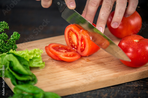 Male hands cutting vegetables for salad