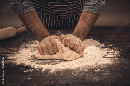 Φωτογραφία Male hands knead the dough.
