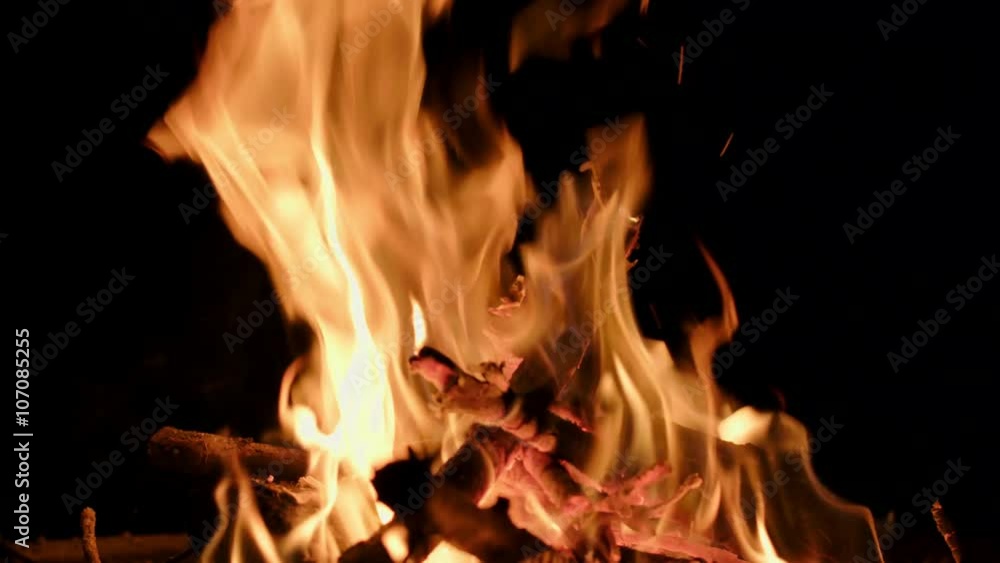 Wood burning and flames rising up from a back-yard fire pit at night. Slow motion, recorded in 4K at 60fps. Wood burning and flames rising up from a back-yard fire pit at night. Slow motion, recorded in 4K at 60fps.