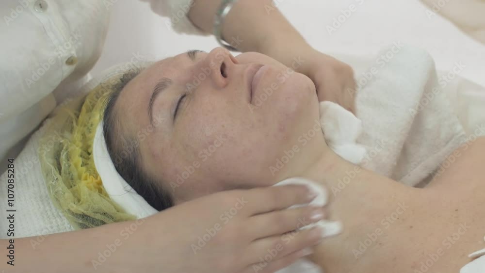 Close up of cosmetologist wipe woman face by napkin after mask in beauty saloon. Problem skin. Cosmetic procedure. Close up of cosmetologist wipe woman face by napkin after mask in beauty saloon. Problem skin. Cosmetic procedure.