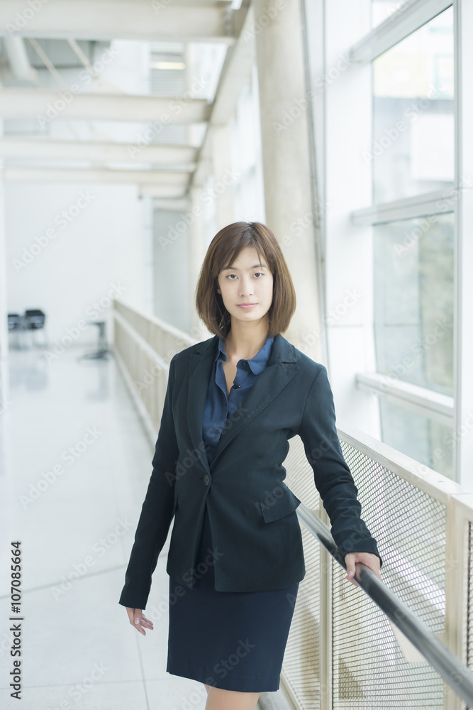 Attractive asian business woman smiling outside office Attractive asian business woman smiling outside office