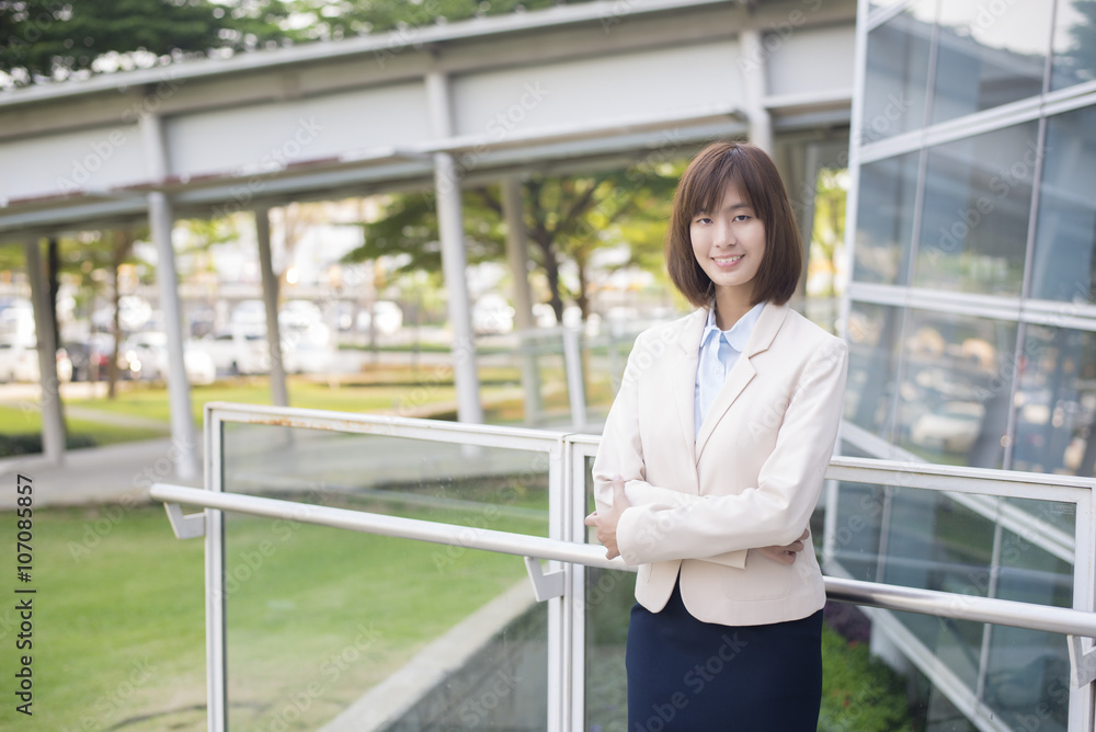 Attractive asian business woman smiling outside office Attractive asian business woman smiling outside office