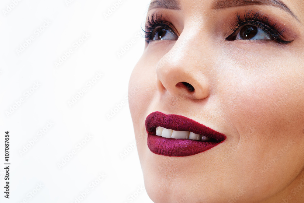 Obraz premium beautiful brunette girl in a black dress smiling. lips painted purple lipstick 