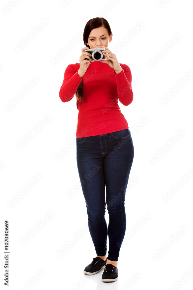 Pretty woman taking a photo using classic slr camera