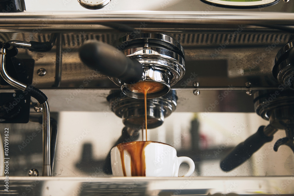 Fresh espresso coffee brewing through the bottomless portafilter in