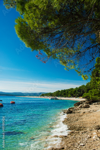 beautiful rocky beach  in Croatia with a view on Zlatni Rat or Golden Cape beach © samael334